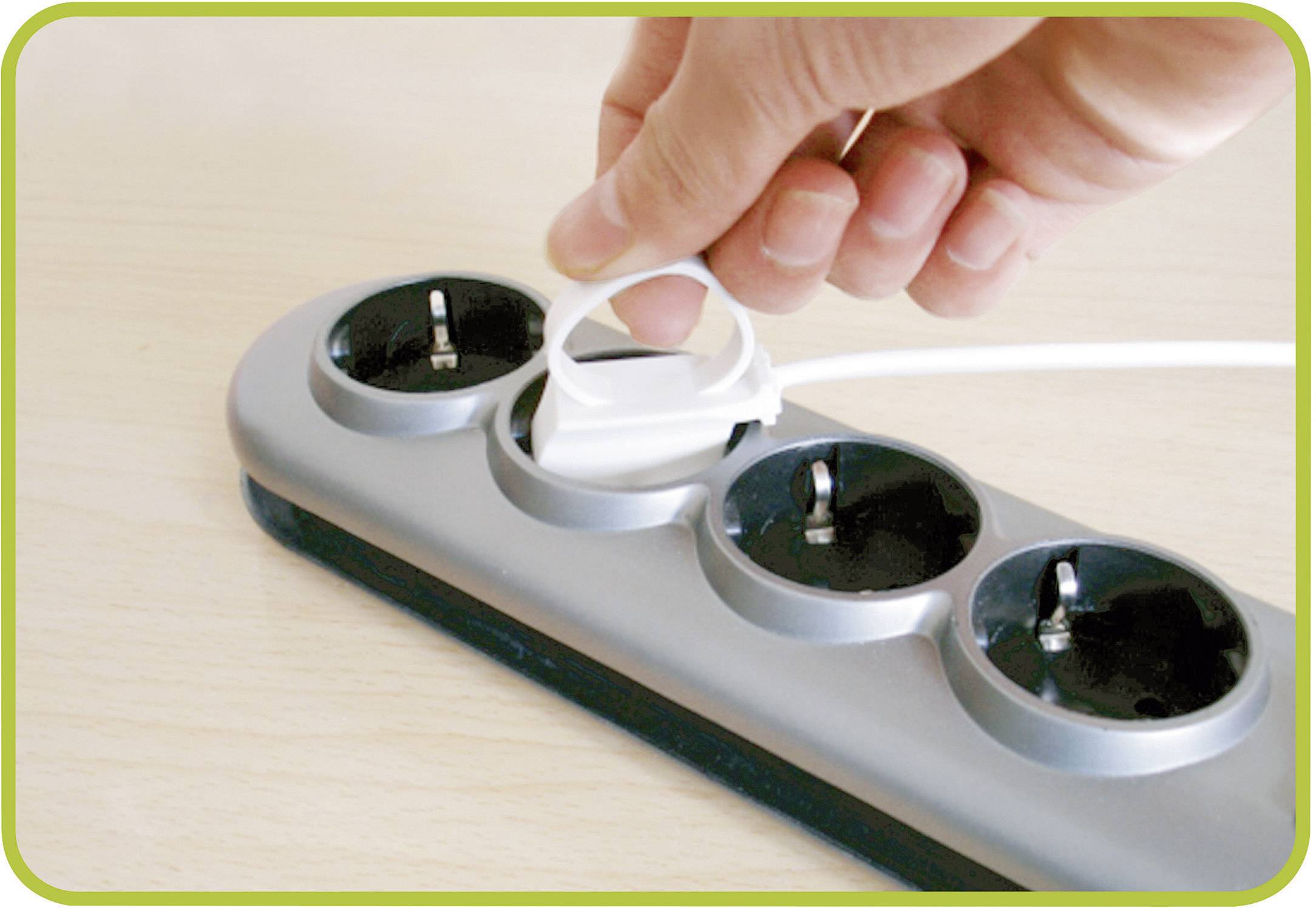 Hand steckt einen Kindersicherheitsverschluss in eine Mehrfachsteckdose zum Schutz vor Stromschlägen.