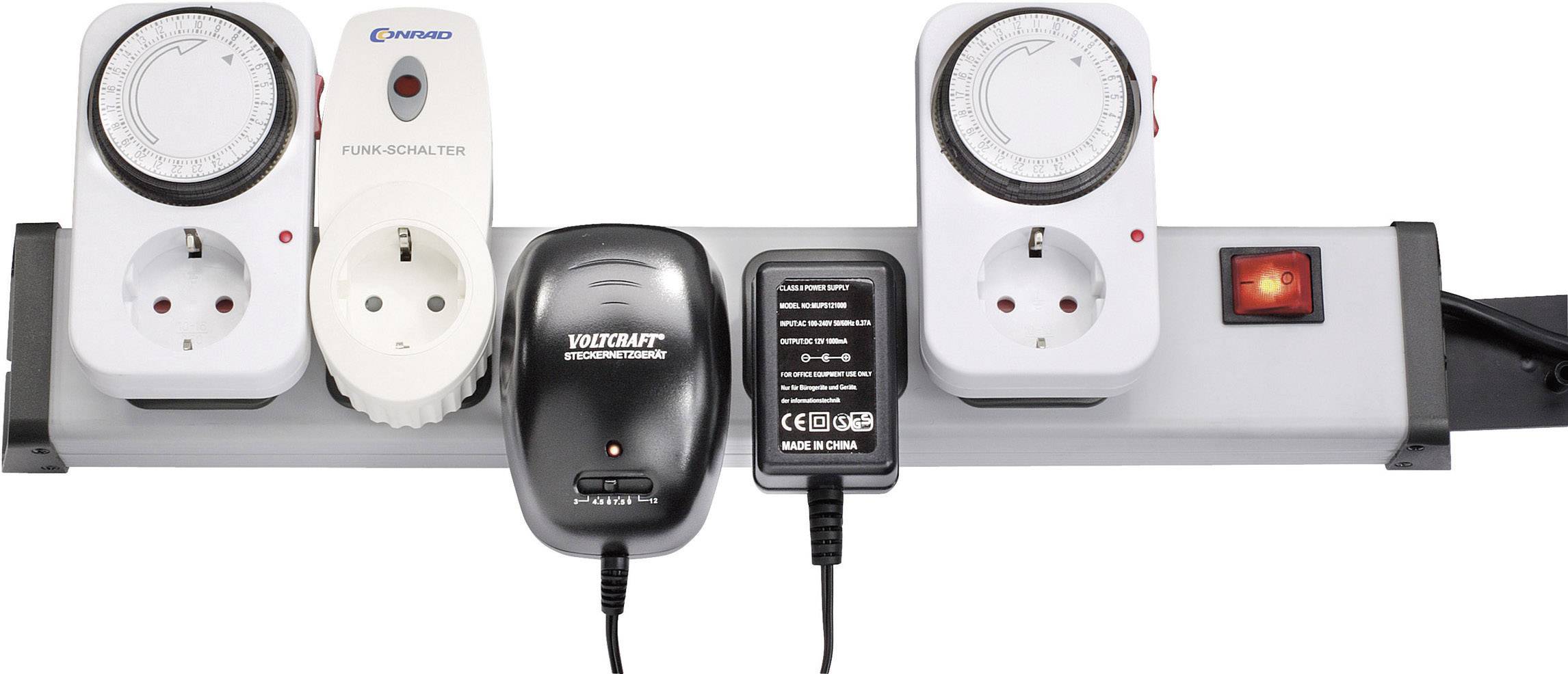 Mehrfachsteckdose mit vier Steckplätzen. Eingesteckt sind zwei Zeitschaltuhren, ein Funk-Dimmer, ein Ladegerät und ein Netzadapter.