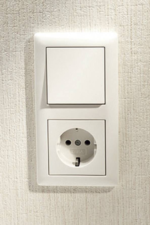 Eine weiße Steckdose mit Schalter an einer hellbeigen Wand.