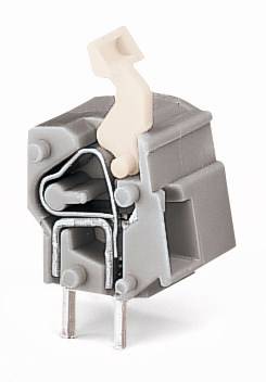 Ein graues, mechanisches Bauteil mit zwei Metallstiften und einer beige Kunststoffkomponente, möglicherweise ein elektrischer Schalter.