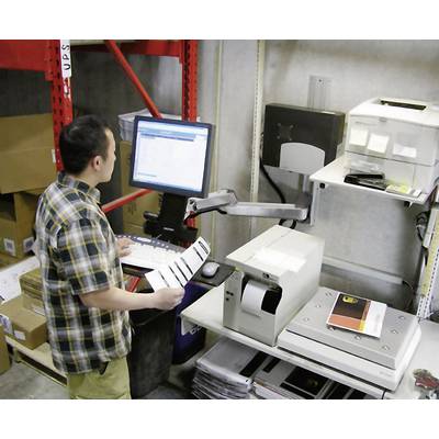 Eine Person steht in einem Lager und bedient einen Computer. Neben dem Monitor befinden sich ein Drucker und ein Barcode-Scanner.