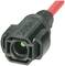 Ein schwarzer, rechteckiger Stecker mit rotem Kabel, vorne eine grüne Leuchtdiode.