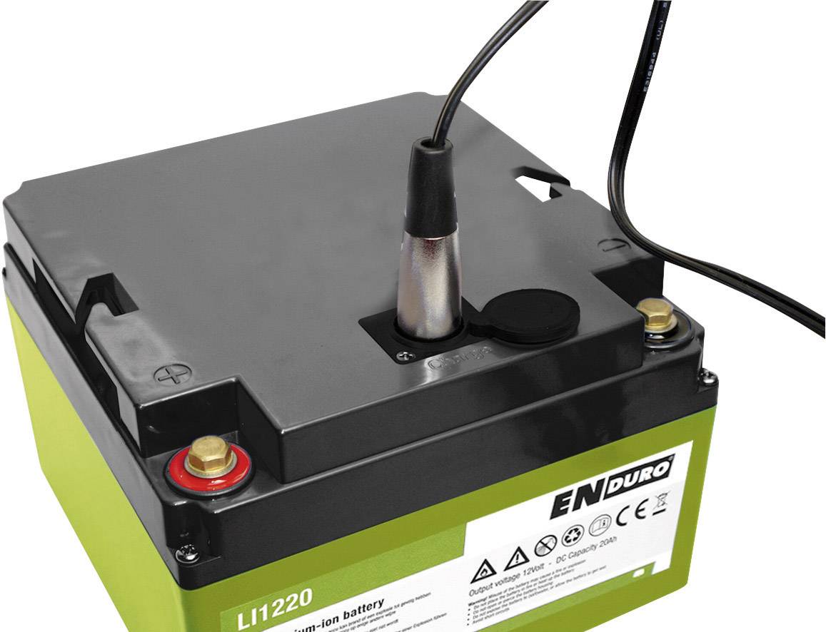 Eine grüne und schwarze Batterie mit einem angeschlossenen Ladegerät. Aufkleber zeigt Symbole und Warnhinweise.