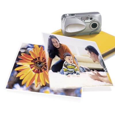Ein silberner Fotoapparat neben einem gelben Fotoalbum. Zwei Fotos: Eines zeigt eine leuchtend orange Blume, das andere eine Familie mit Baby beim Spielen auf einem Teppich.