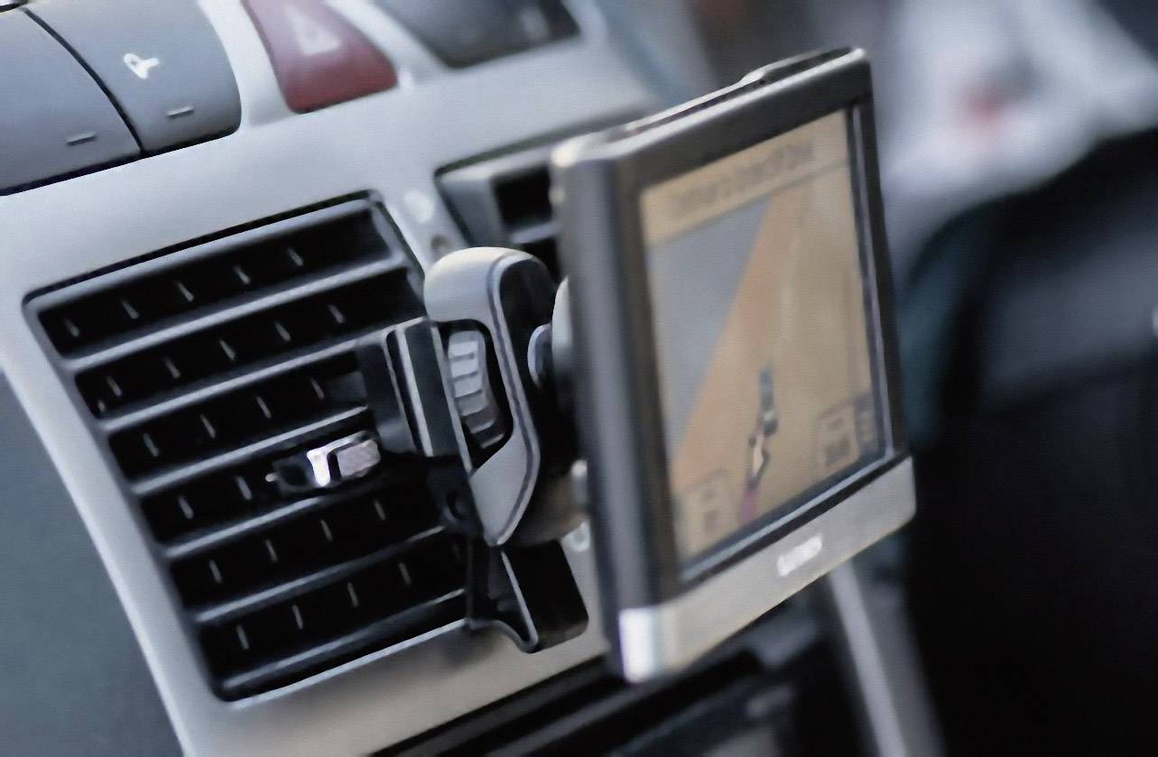 Ein Navigationsgerät ist an einer Autolüftung befestigt und zeigt eine Straßenroute an.