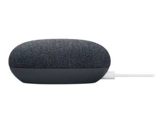 Ein schwarzer Google Nest Mini von der Seite. Ein weißes USB-C-Kabel steckt im Port. Der Hintergrund ist weiß.