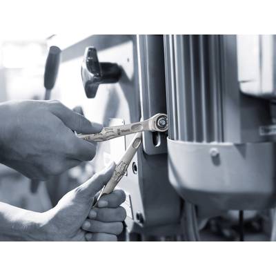 Zwei Hände benutzen Schraubenschlüssel, um eine Maschine zu reparieren. Der Fokus liegt auf der präzisen Befestigung von Schrauben.