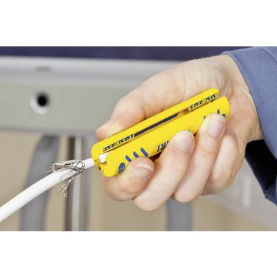 Eine Hand hält ein gelbes Werkzeug, das ein weißes Kabel abisoliert und freiliegende Drähte zeigt.