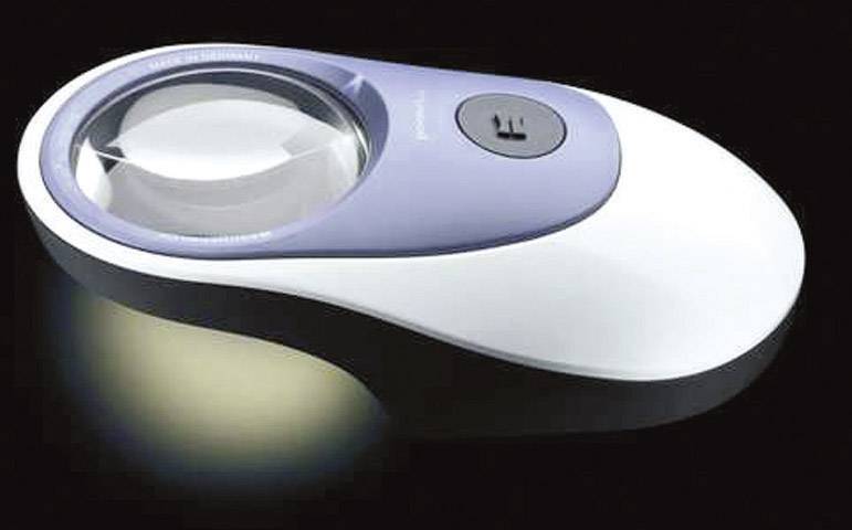 Eine weiße, ergonomisch geformte Maus mit einer integrierten Lupe auf der Oberseite, die auf einer dunklen Oberfläche liegt.