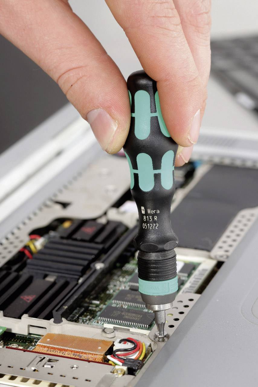 Eine Hand zieht mit einem Schraubendreher eine Schraube in einem Computergehäuse fest. Im Hintergrund sind Computerkomponenten zu sehen.