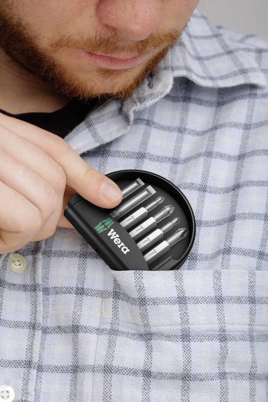 Ein Mann in einem karierten Hemd steckt fünf silberne USB-Sticks mit der Aufschrift 'Word' in seine Brusttasche.