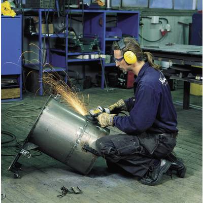 Eine Person mit Schutzbrille und Ohrenschützern schweißt Funken sprühend an einem großen Metallzylinder in einer Werkstatt.