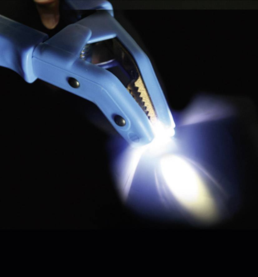 Eine blaue Klemme hält einen glänzenden Metallgegenstand und erzeugt einen hellen Lichtblitz, der die Umgebung beleuchtet.