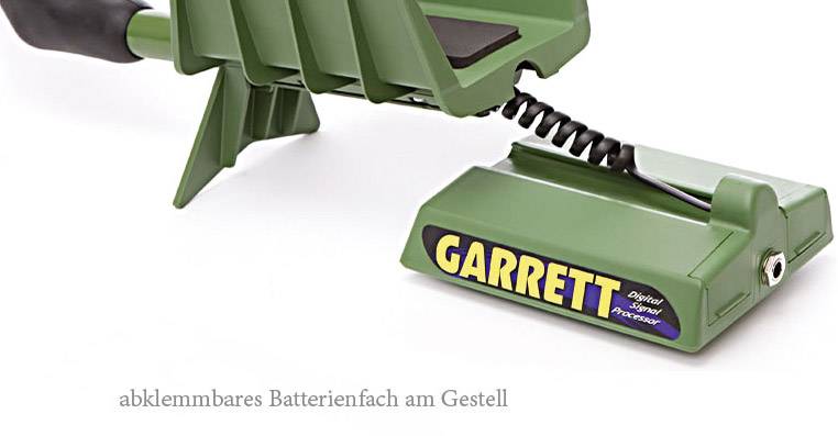Abnehmbares Batteriefach eines grünen Metalldetektors mit Spiralverbindung, darauf steht 'Garrett'.