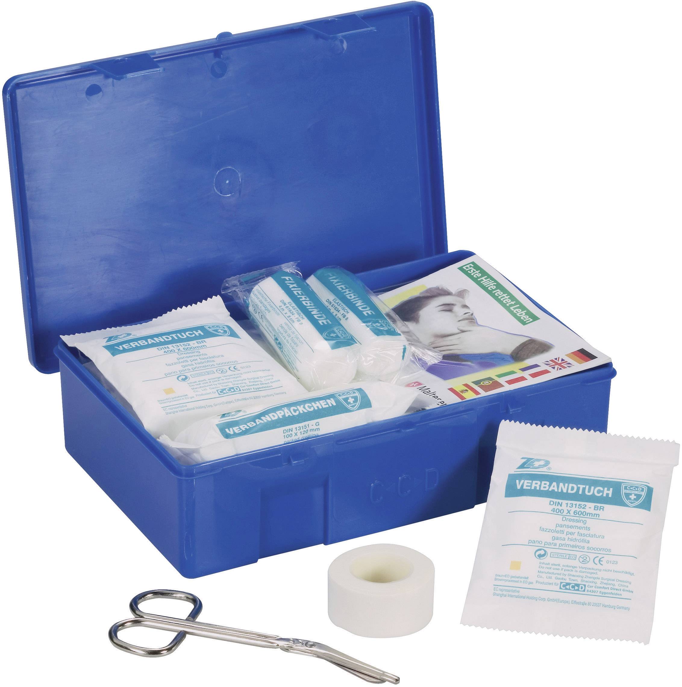 Blaue Erste-Hilfe-Box mit verschiedenen Verbandsmaterialien, Schere und Klebeband. Anleitung in mehreren Sprachen enthalten.