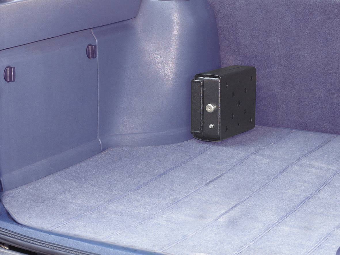 Ein kleiner schwarzer Safe ist im Kofferraum eines Autos befestigt. Der Innenraum ist mit blauem Stoff ausgekleidet.