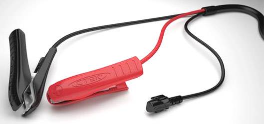 Ein rotes und ein schwarzes Batterieladekabel mit Klemmen, verbunden durch ein Kabel, auf grauem Hintergrund.