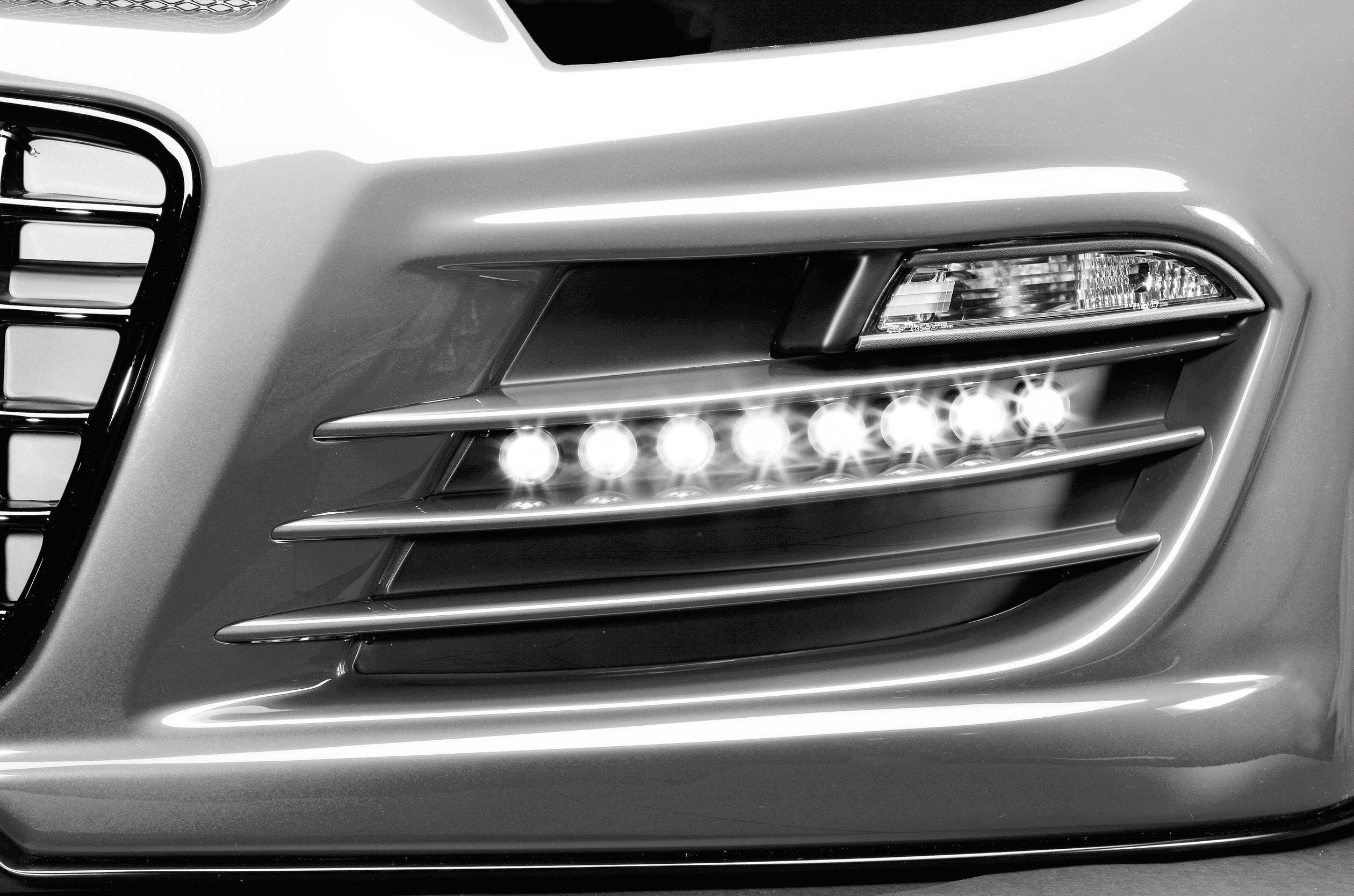 Nahaufnahme eines Autoscheinwerfers und Lufteinlass an der Vorderseite eines Fahrzeugs, mit LED-Tagfahrleuchten.