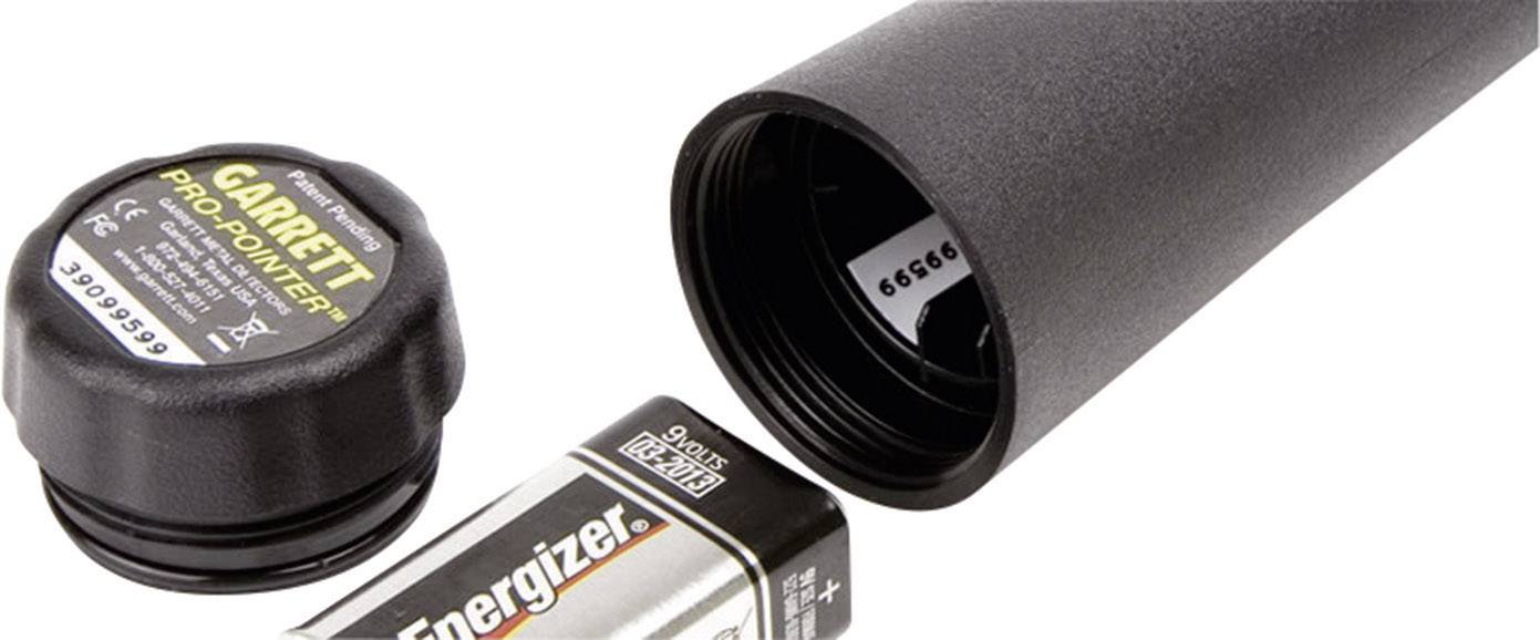 Schwarzer Metalldetektor, Batteriefach geöffnet, zeigt eine 'Energizer'-Batterie und eine schwarze Schutzkappe mit 'Garrett Pro-Pointer' Aufschrift.