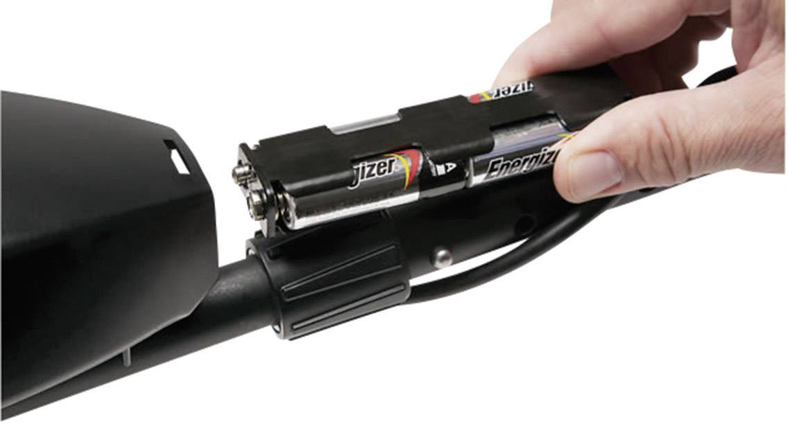 Eine Hand setzt zwei AA-Batterien in ein schwarzes Gerät ein, das mit einem Kabel verbunden ist.