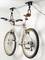 Ein silbernes Fahrrad hängt mithilfe eines an der Decke befestigten Haltersystems, das Seilzüge verwendet, um Platz zu sparen.