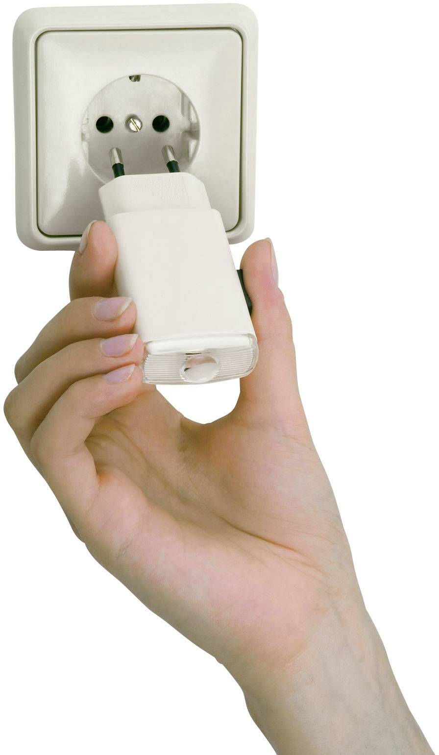 Eine Hand hält einen weißen Stecker, der in eine weiße Steckdose gesteckt wird.