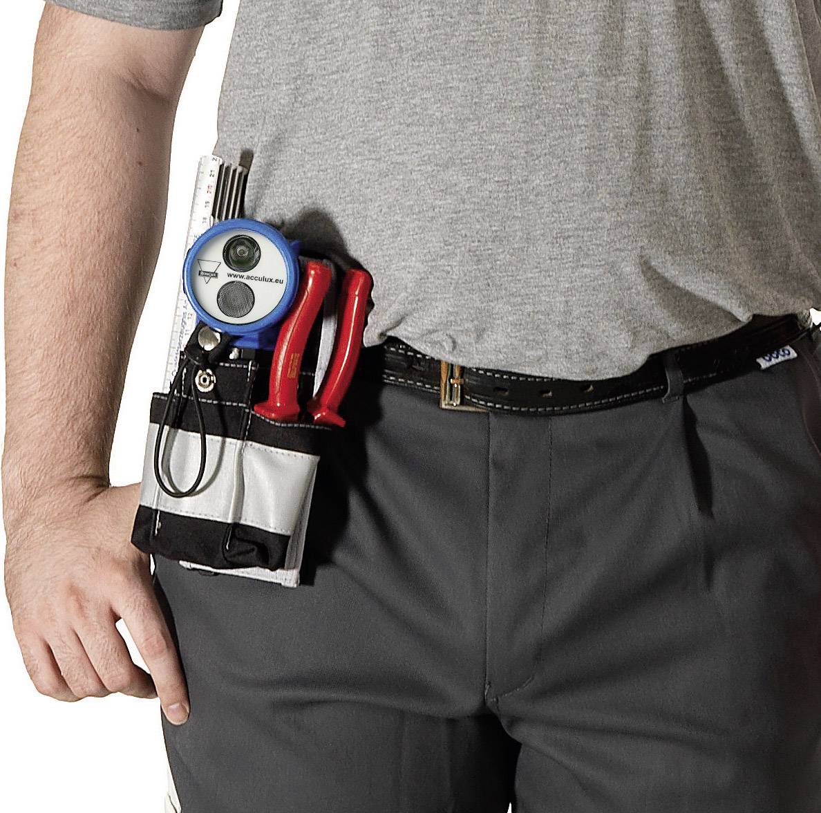 Ein Mensch trägt eine graue Hose und ein graues T-Shirt. In der Hosentasche sind Werkzeuge wie Schraubenzieher und ein Maßband.