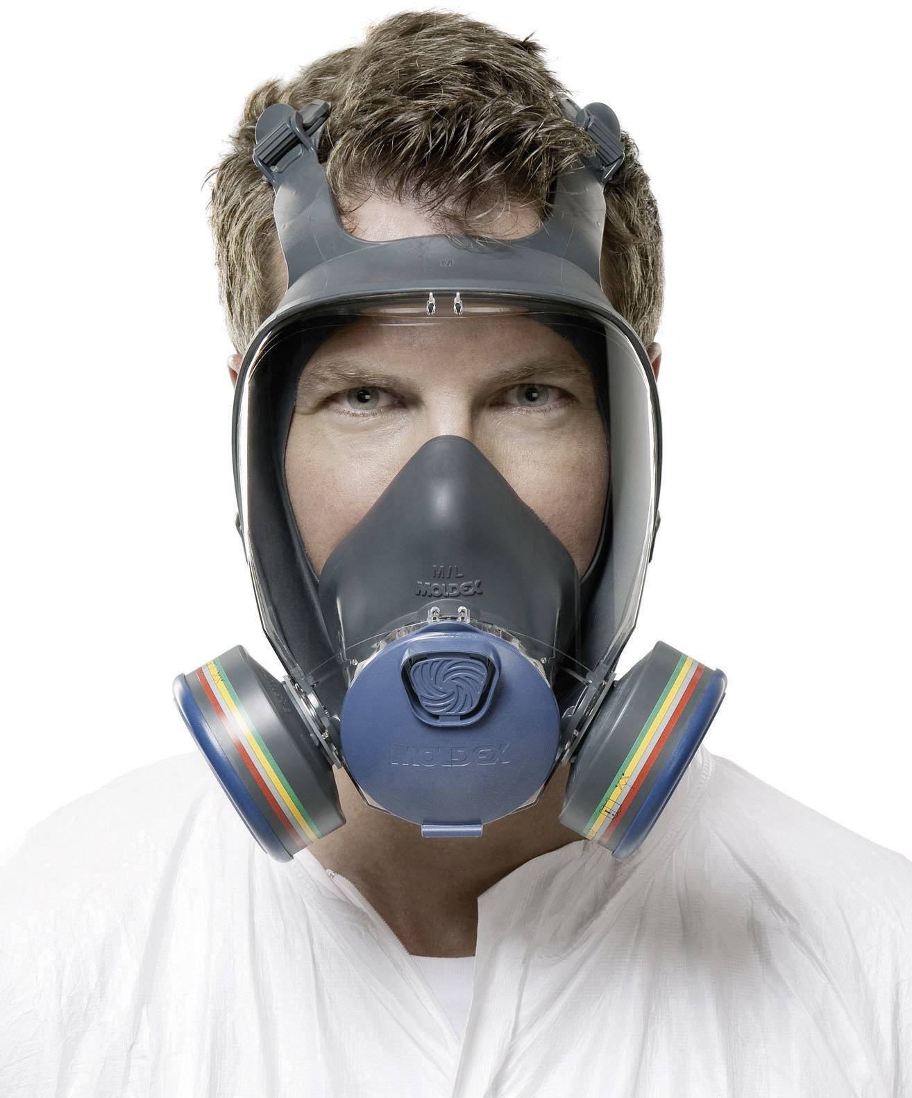 Ein Mann trägt eine Gasmaske mit bunten Filtern, die sein Gesicht vollständig bedeckt.