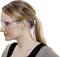 Eine Frau mit zusammengebundenem Haar trägt eine Schutzbrille und einen gelben Ohrstöpsel.