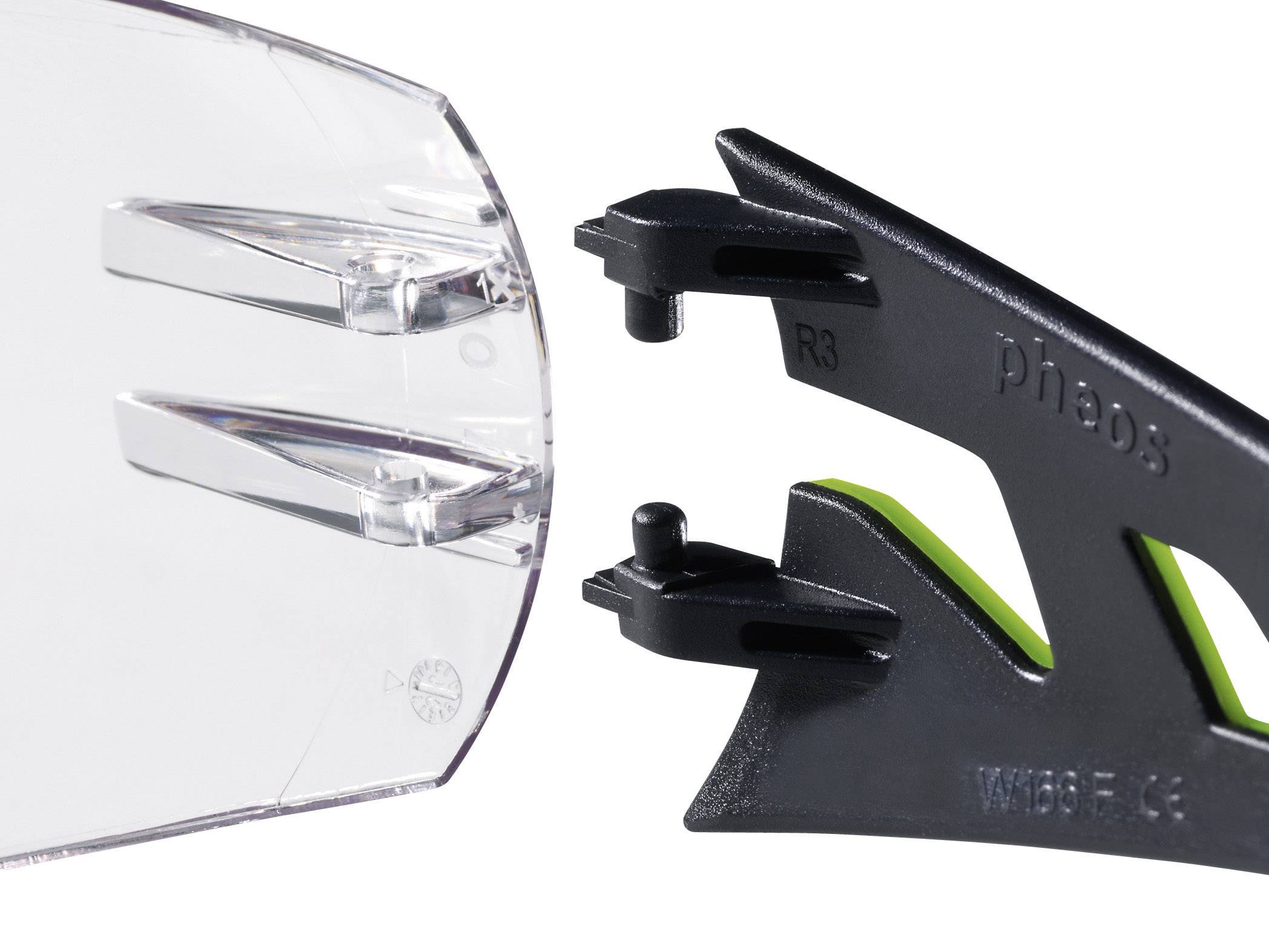 Nahaufnahme einer transparenten Schutzbrille, die an einem schwarzen Brillenrahmen mit grünem Detail befestigt wird.