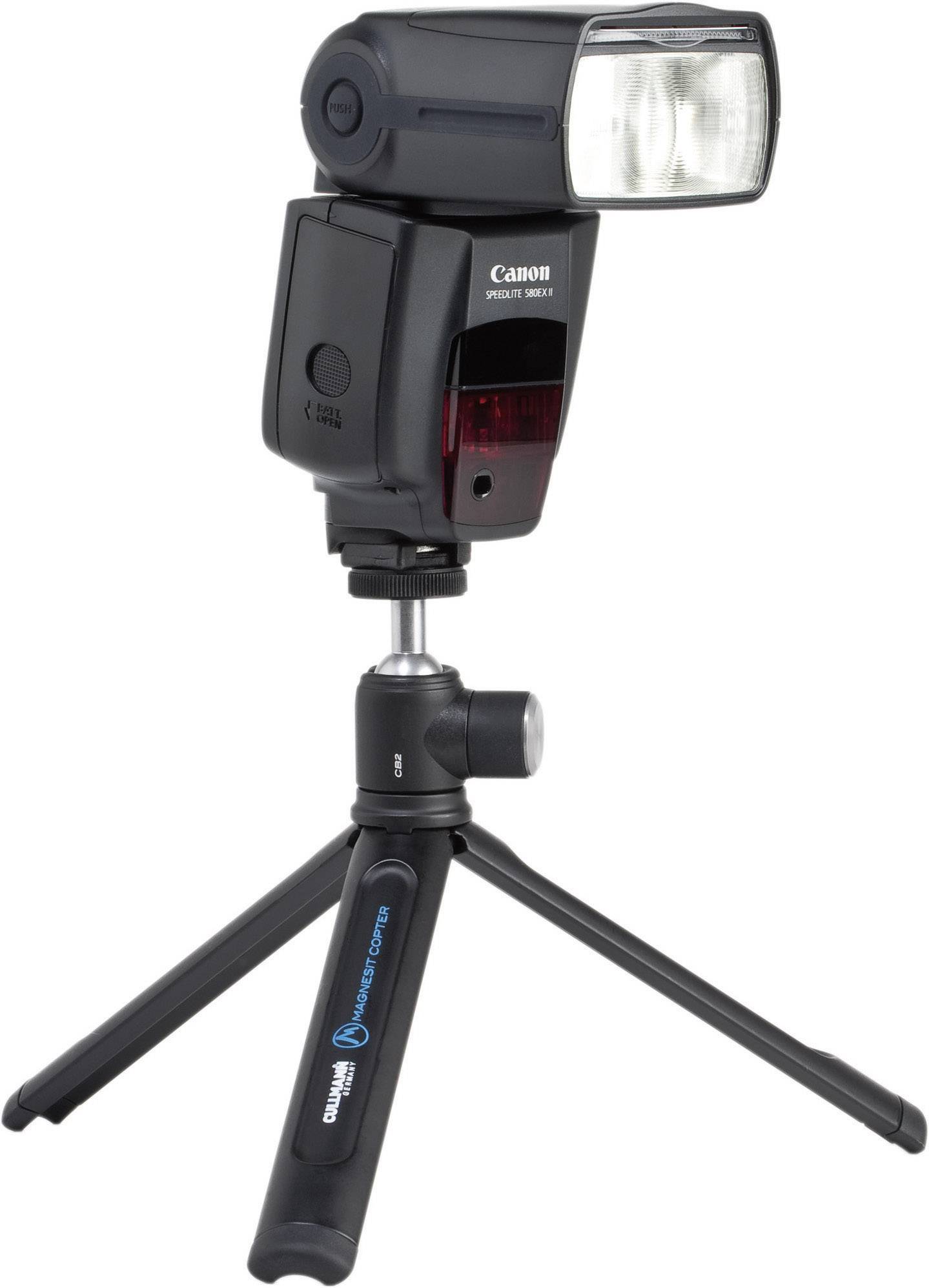 Ein schwarzer Kamerablitz mit Blitzkopf ist auf einem kleinen Stativ montiert.