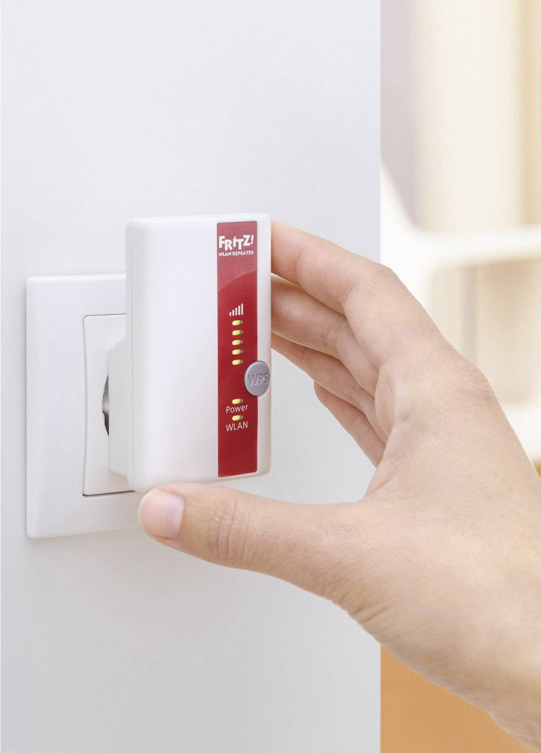 'Hand steckt WLAN-Repeater in Steckdose'; zeigt grundlegende Nutzung eines WLAN-Verstärkers zur Verbesserung des Internetempfangs.