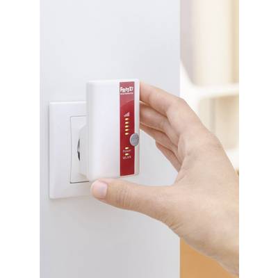 'Hand steckt WLAN-Repeater in Steckdose'; zeigt grundlegende Nutzung eines WLAN-Verstärkers zur Verbesserung des Internetempfangs.