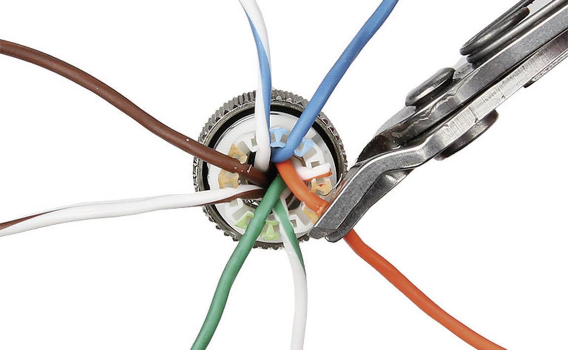 Mehrfarbige Kabel werden mit einem Stecker verbunden. Eine Zange hält den orangefarbenen Draht.