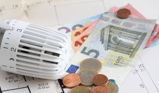 Geld sparen beim Heizen Das Bild zeigt ein Heizkörperthermostat und Geld. Dadurch wird veranschaulicht, dass man beim Heizen richtig viel Geld sparen kann.