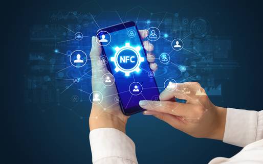 Auf dem Bild wird ein Smartphone gezeigt, das eine Person bedient. Auf dem Display sind die Buchstaben NFC zu sehen und die Vernetzungsmöglichkeiten werden in einer bläulich getönten grafischen Überblendung dargestellt. 