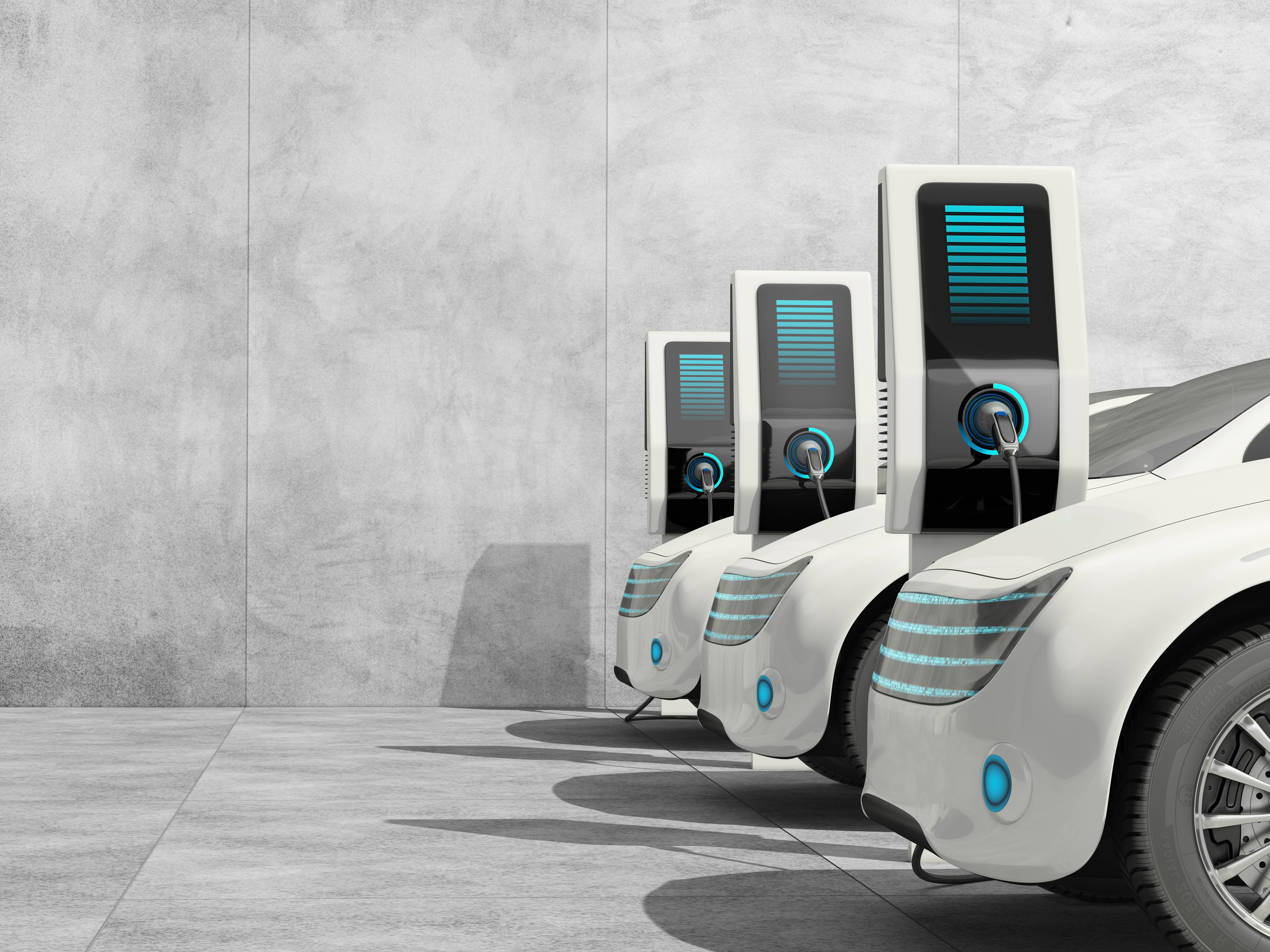 Drei futuristisch aussehende E-Autos sind mit Ladesäulen verbunden und "tanken".