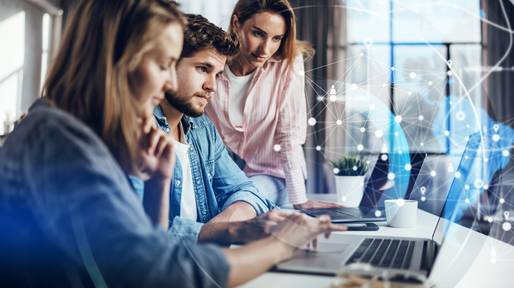 Drei Mitarbeiter nutzen digitalisierte Prozesse am Laptop, um Smart Procurement Strategien umzusetzen.