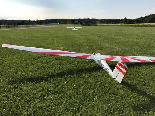Das Bild zeigt, wie ein Modellsegelflugzeug darauf wartet, von einem Motor-Modellflugzeug in den Himmel geschleppt zu werden.