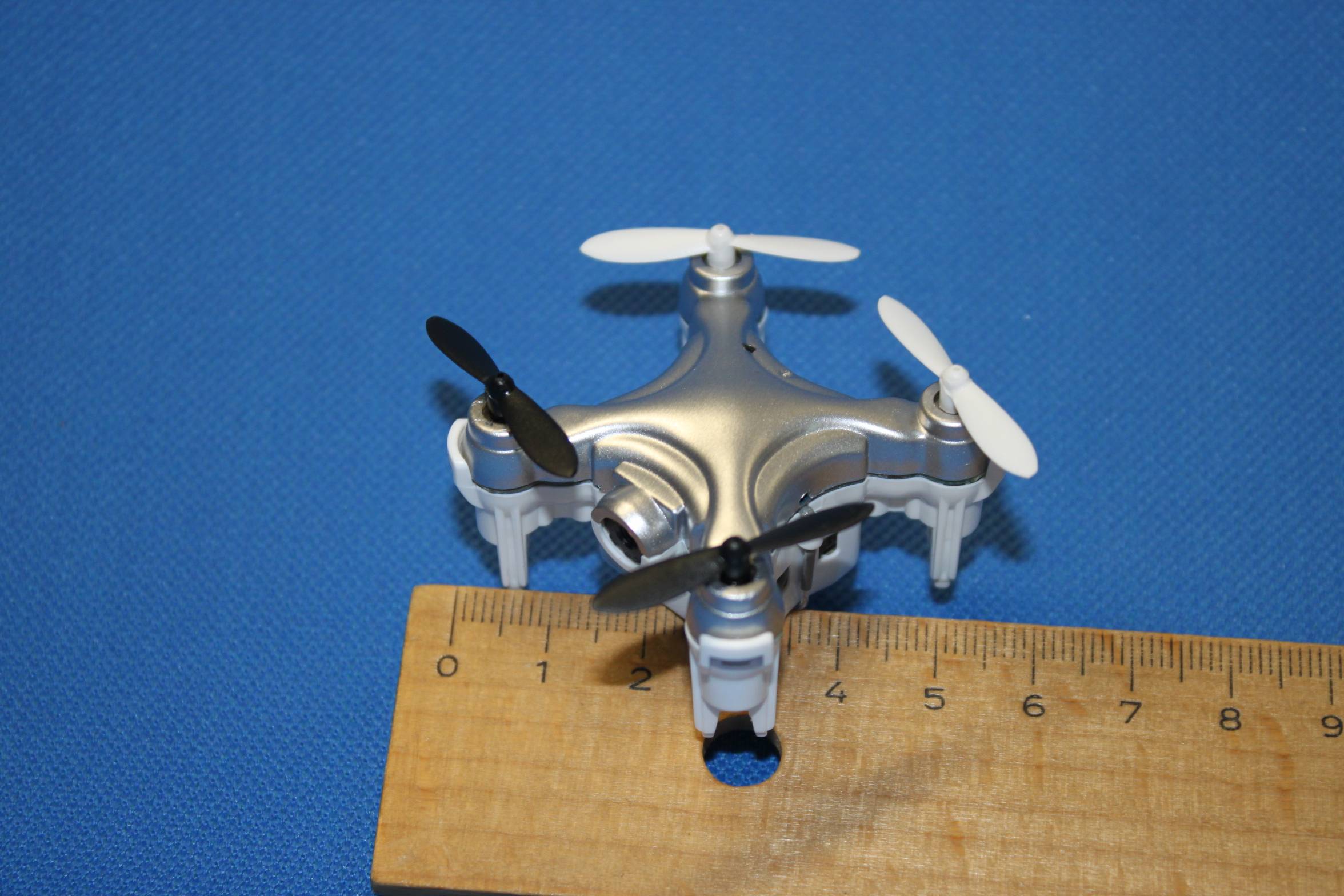 Das Bild zeigt eine Einsteiger-Drohne, bei der zum Größenvergleich ein Lineal mit abgebildet ist.