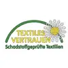 Das Bild zeigt das Logo 'Textiles Vertrauen' für schadstoffgeprüfte Textilien, mit einem grünen Bogen und gelb-weißen Elementen.