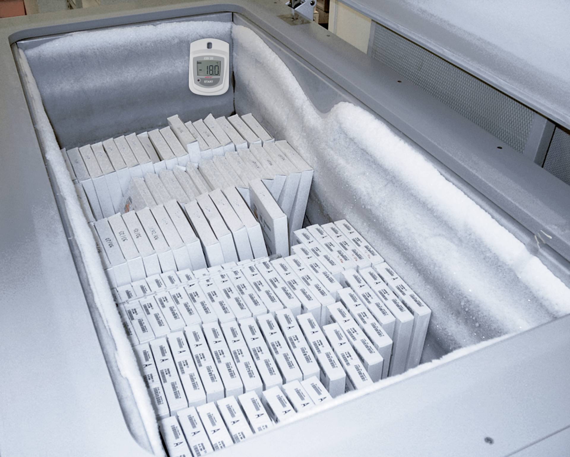 Freezer with stacked white boxes. A thermometer indicates a temperature of minus 80 degrees Celsius.