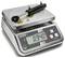 A digital scale shows the weight of a metal cylinder as 0.940 kg. The scale has buttons for On/Off, Tare, and Unit.