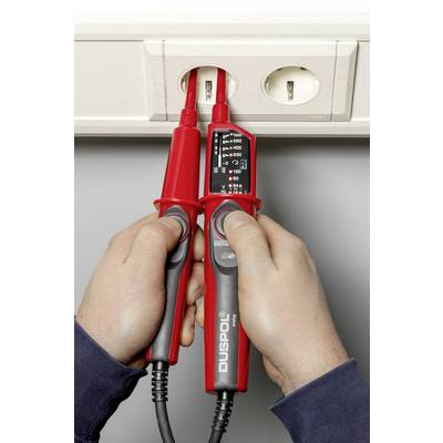 A person is measuring the current flow at a socket using a voltage tester. The tester indicates 230 volts.