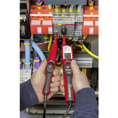 A technician measures 403 volts with a voltage tester on an electrical switchboard.