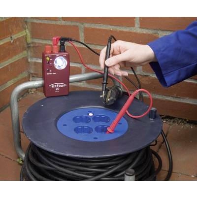 A hand is using a test device to check the functionality of a multi-socket extension reel.