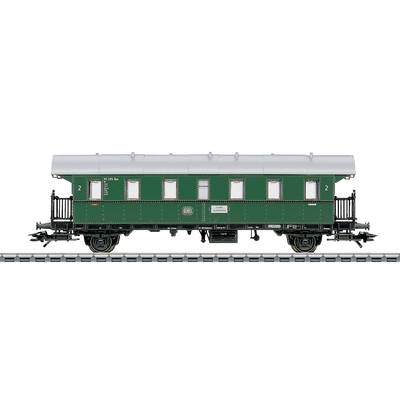 Historic green railway carriage in the 1920s style on the track.