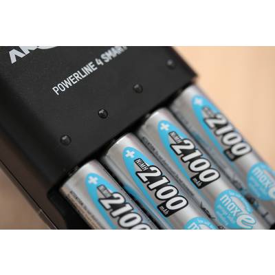 A charger is charging four AA batteries labelled '2100 mAh'. Underneath it says 'maxE'. Part of the brand name is visible.