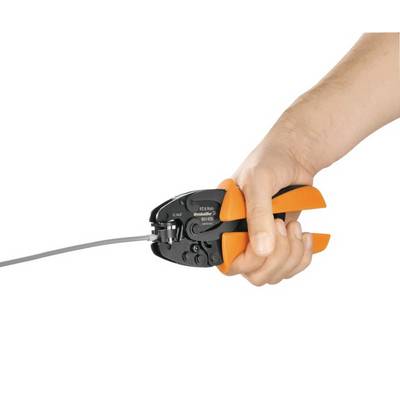 A hand holds an orange-black crimping plier working on a cable.