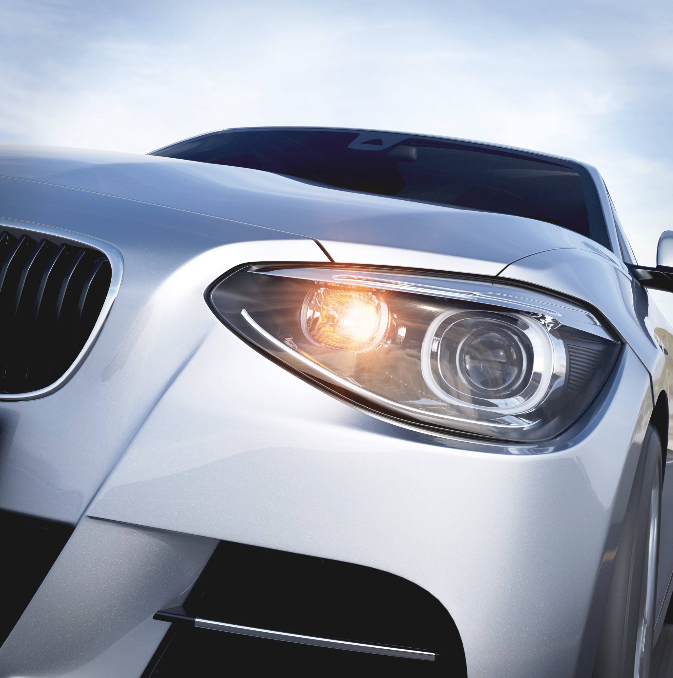 Silver car with indicator on, photographed from the front right. The sky is slightly cloudy in the background.